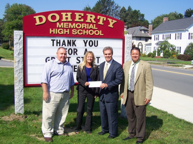 DA Early presents a check to Doherty High principal Sally Maloney as football coach Sean Mulcahy and assistant principal Ed Capstick look on.